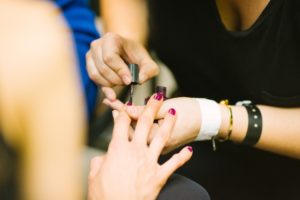 A woman getting her nails painted.