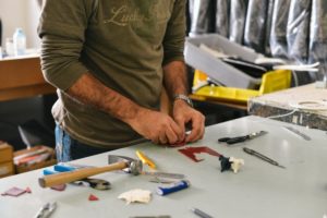 A man standing at a table with tools.